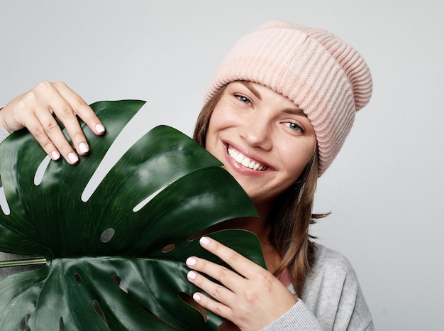 Concept d'émotion et de personnes de style de vie Belle jeune femme tenant une feuille d'une grande fleur tropicale