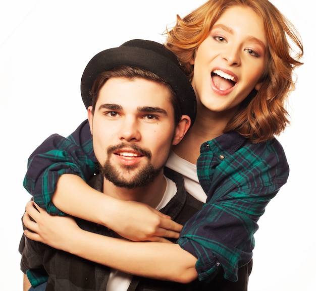 Concept émotionnel, bonheur et personnes : couple d'amoureux heureux. Jeune homme ferrouillant sa petite amie. Prise de vue en studio sur fond blanc. Photos spéciales de tonification à la mode.