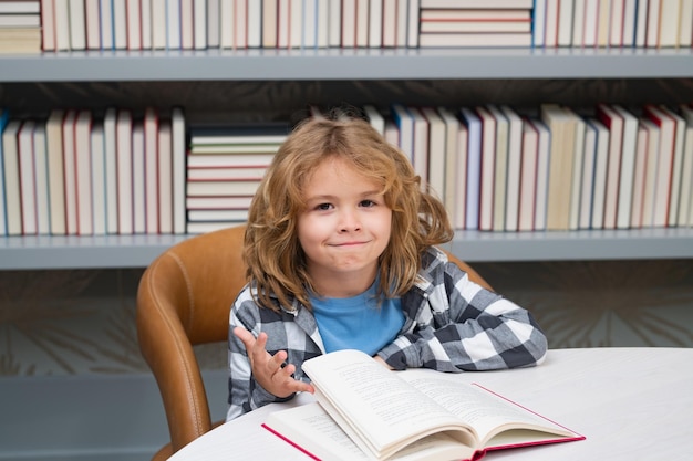 Concept d'enfance et d'éducation Enfant dans la bibliothèque lit des livres Écolier choisissant un livre dans la bibliothèque de l'école Littérature pour enfants à lire Enfant dans une librairie Apprendre des livres