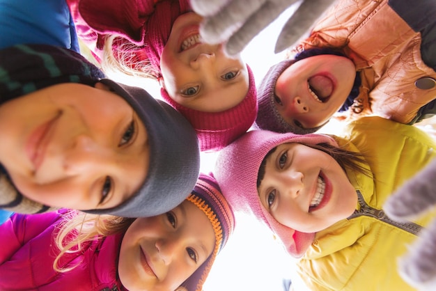 concept d'enfance, de loisirs, d'amitié et de personnes - groupe d'enfants heureux fait face en cercle