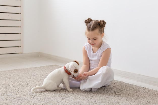 Concept d'enfants et d'animaux - Chiot avec son propriétaire assis sur le sol.