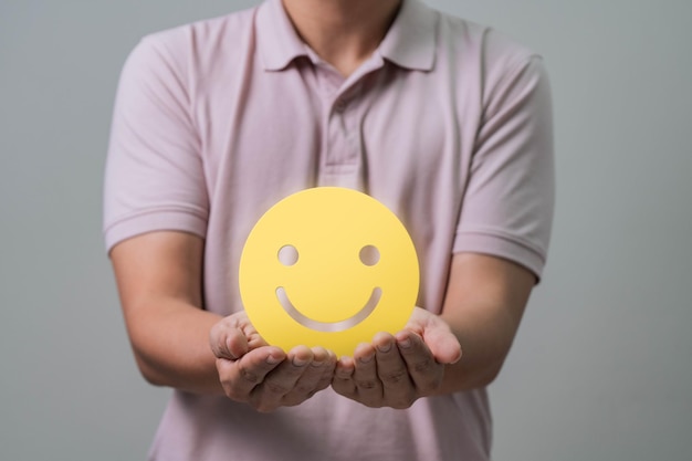 Photo concept d'enquêtes de satisfaction du client la main du client montre une rétroaction avec un signe de visage souriant