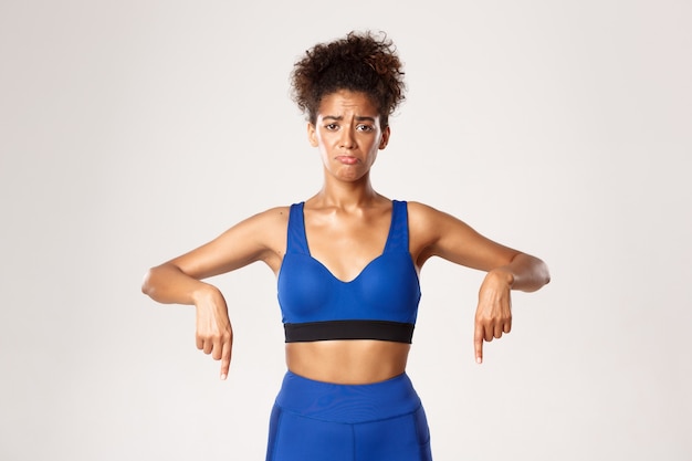 Photo concept d'entraînement et de remise en forme. athelte fille afro-américaine triste et sombre, vêtue de bleu