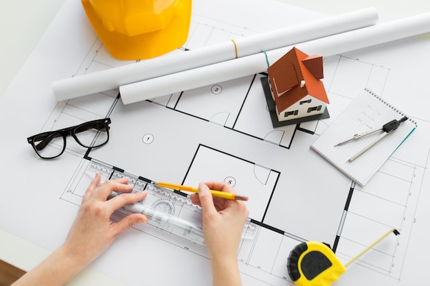 concept d'entreprise, d'architecture, de bâtiment, de construction et de personnes - gros plan des mains d'architecte avec règle et crayon mesurant le plan de la maison d'habitation