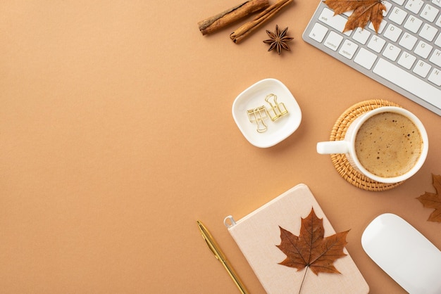 Concept d'entreprise d'automne Vue de dessus photo d'une tasse de café sur un tapis de service en rotin Journal stylo souris d'ordinateur clavier bâtons de cannelle feuilles d'érable jaune anis et pinces à reliure sur fond beige isolé