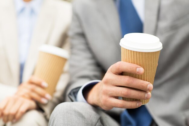 concept d'entreprise, de boissons chaudes et de personnes - gros plan sur des mains d'hommes d'affaires avec des tasses à café