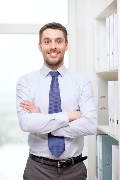 concept d'entreprise et de bureau - bel homme d'affaires avec les bras croisés au bureau