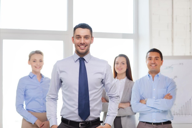 concept d'entreprise et de bureau - bel homme d'affaires souriant avec équipe au bureau