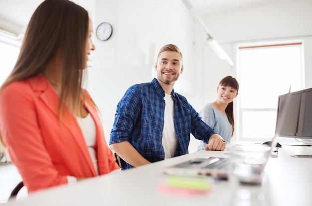 concept d'entreprise, de communication, de démarrage et de personnes - équipe créative multiraciale heureuse parlant au bureau