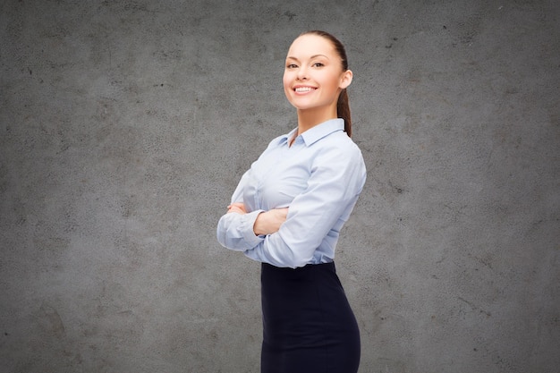 concept d'entreprise et d'éducation - sympathique jeune femme d'affaires souriante aux bras croisés