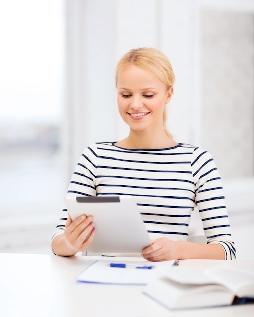 concept d'entreprise, d'éducation et de technologie - étudiant souriant avec livre, ordinateur tablette et ordinateur portable à l'université