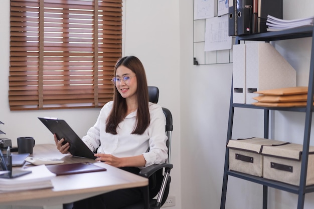 Concept d'entreprise Femme d'affaires tenant le presse-papiers et lisant le document d'entreprise au budget d'analyse