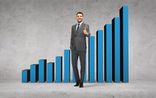 concept d'entreprise, de geste et de bureau - bel homme d'affaires montrant les pouces vers le haut avec un graphique croissant à l'arrière