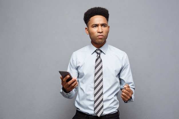 Concept d'entreprise - homme d'affaires afro-américain stressant criant et criant sur téléphone mobile.