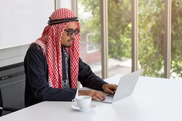 Concept d&#39;entreprise; Homme d&#39;affaires arabe travaillant avec l&#39;ordinateur pour la communication dans les bureaux modernes