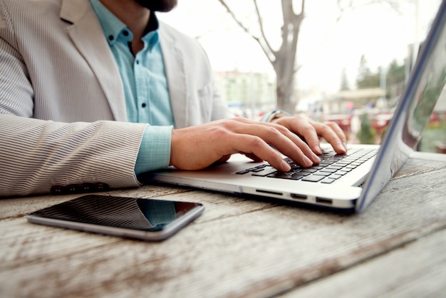 Concept d'entreprise. Homme tapant clavier d'ordinateur portable faible profondeur de champ.