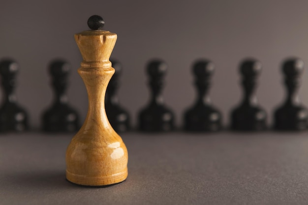 Concept d'entreprise de leadership abstrait avec des pièces d'échecs. Figure de la reine debout contre la ligne de petits pions, espace de copie