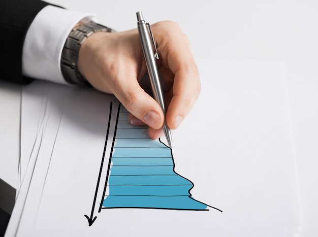 concept d'entreprise, de marketing, de planification et de personnes - gros plan d'une main masculine avec un graphique de dessin au stylo sur du papier blanc