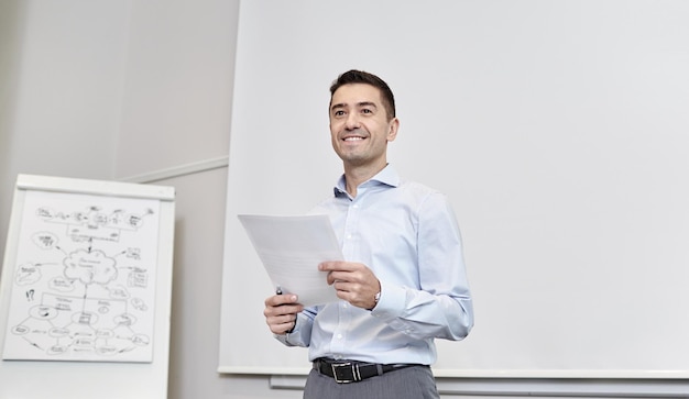 concept d'entreprise et de personnes - homme d'affaires souriant sur présentation au bureau