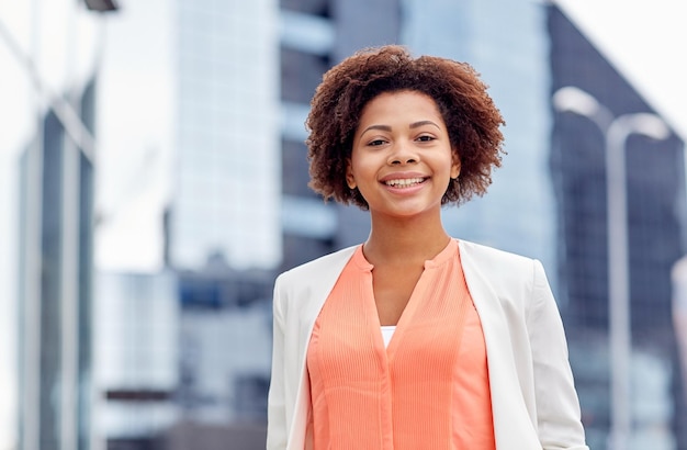 concept d'entreprise et de personnes - jeune femme d'affaires afro-américaine souriante en ville
