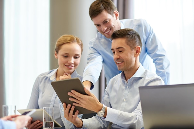 concept d'entreprise, de personnes et de technologie - équipe commerciale souriante avec réunion d'ordinateur tablette pc au bureau