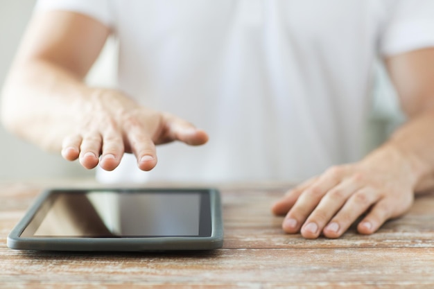 concept d'entreprise, de personnes et de technologie - gros plan sur des mains masculines avec un ordinateur tablette sur la table