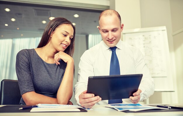 concept d'entreprise, de personnes, de technologie et de travail d'équipe - homme d'affaires et femme d'affaires souriants avec une réunion d'ordinateur tablette pc au bureau