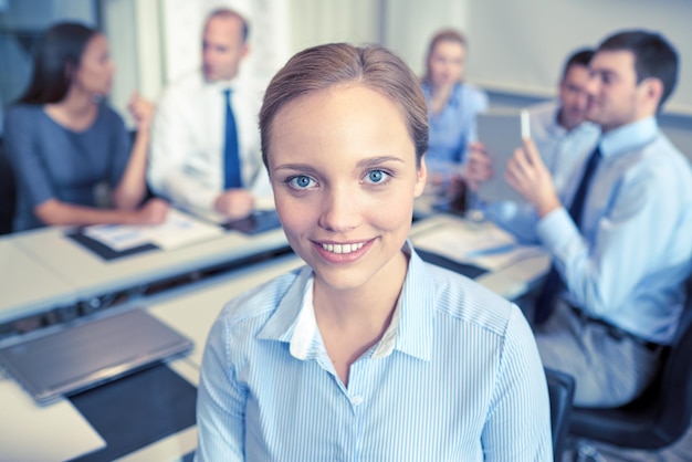 concept d'entreprise, de personnes et de travail d'équipe - femme d'affaires souriante avec un groupe d'hommes d'affaires réunis au bureau