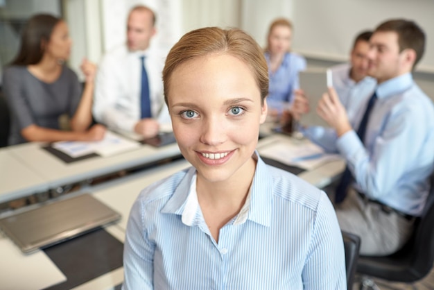 concept d'entreprise, de personnes et de travail d'équipe - femme d'affaires souriante avec un groupe d'hommes d'affaires réunis au bureau