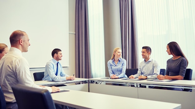 concept d'entreprise, de personnes et de travail d'équipe - groupe d'hommes d'affaires souriants réunis au bureau