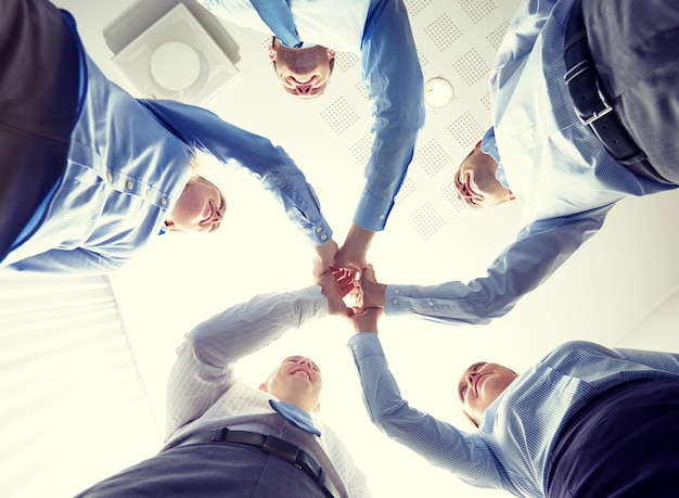 concept d'entreprise, de personnes et de travail d'équipe - groupe souriant d'hommes d'affaires debout en cercle et faisant un geste de cinq