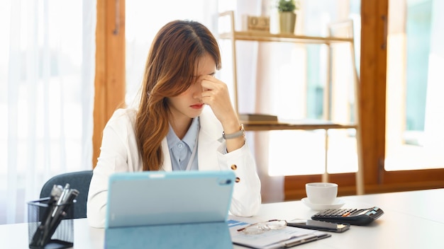 Concept d'entreprise réussi Femme d'affaires se sentant mal à la tête après avoir travaillé dur sur un nouveau projet