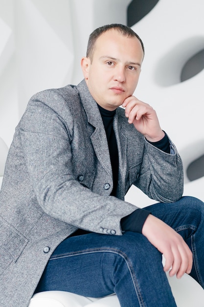 Concept d'entreprise, de santé, de personnes et de style de vie - Chic. Bel homme en veste. Portrait d'un jeune homme d'affaires souriant, les bras croisés, debout au bureau et regardant la caméra.