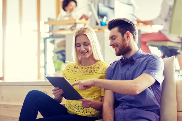 concept d'entreprise, de technologie, de démarrage et de personnes - équipe créative heureuse avec ordinateur tablette pc au bureau