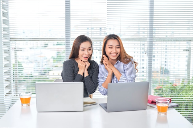 Concept d'entreprise, de travail d'équipe et de personnes - équipe féminine ou femmes d'affaires avec ordinateur portable travaillant au bureau