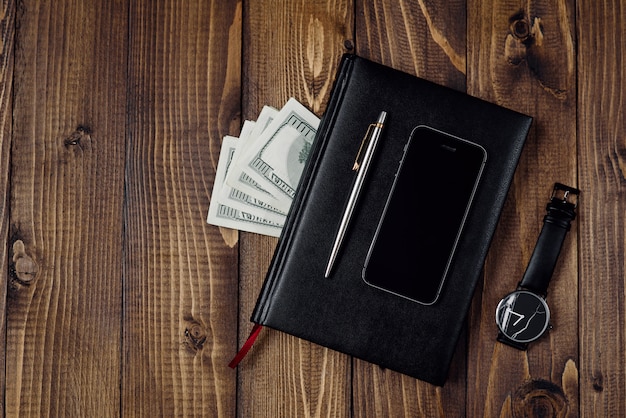Concept d'entreprise - vue de dessus du téléphone, montre, stylo, ordinateur portable et argent.
