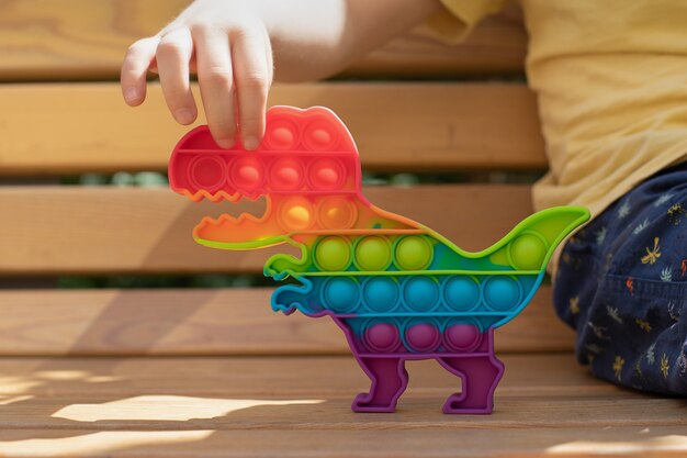 Photo concept d'équilibre émotionnel jouet anti-stress en silicone sensoriel multicolore en forme de dinosaure