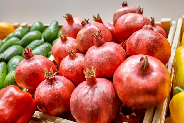 Concept d'étal de fruits frais tas de grenade dans le panier de la boîte noire de l'agriculteur à vendre des fruits rouges pour le fond de texture autour du marché