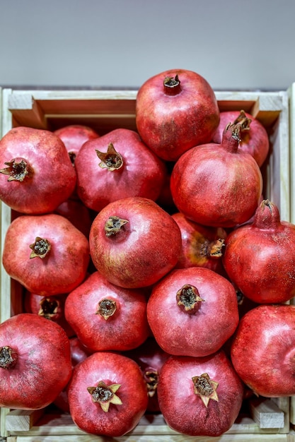 Concept d'étal de fruits frais tas de grenade dans le panier de la boîte noire de l'agriculteur à vendre des fruits rouges pour le fond de texture autour du marché