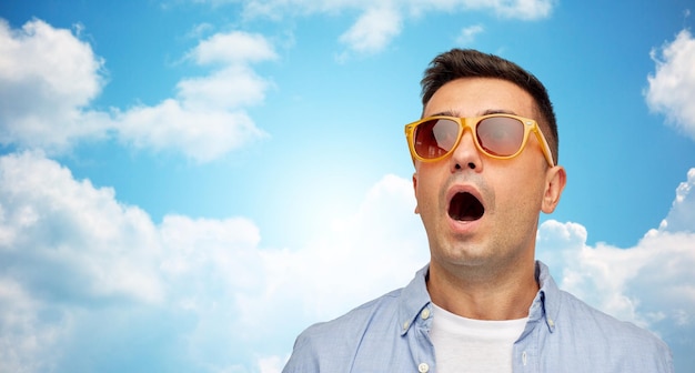 Concept D'été, D'émotions, De Style Et De Personnes - Visage D'un Homme Latin D'âge Moyen Effrayé Ou Surpris En Chemise Et Lunettes De Soleil Sur Fond Bleu Ciel Et Nuages