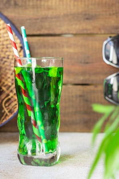Concept d'été de limonade à l'estragon ou au basilic, boisson rafraîchissante verte chapeau de paille se détendre
