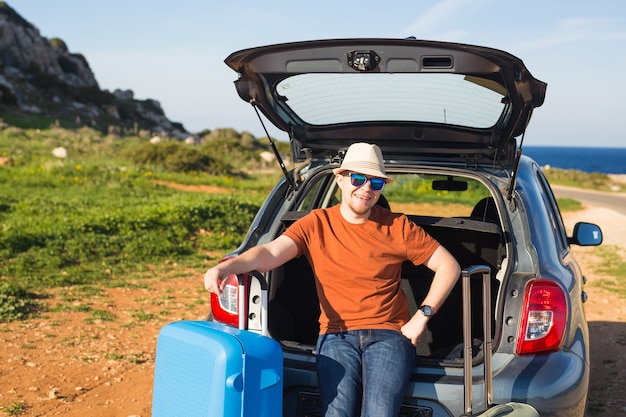 Concept d'été, de vacances, de voyage et de vacances - Homme près de la voiture prêt à voyager.