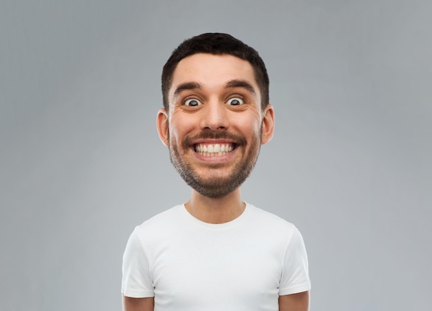 concept d'expression et de personnes - homme souriant avec un visage drôle sur fond gris (personnage de style dessin animé avec grosse tête)