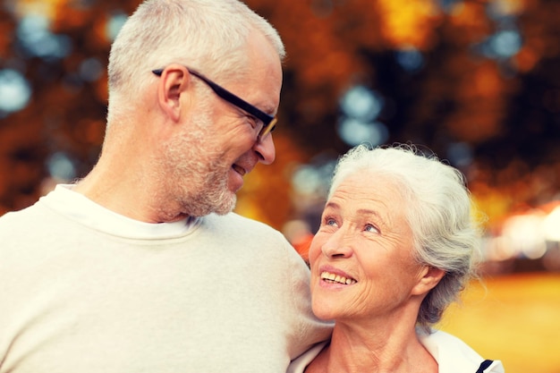 Photo concept de famille, d'âge, de tourisme, de voyage et de personnes - couple de personnes âgées embrassant dans le parc de la ville