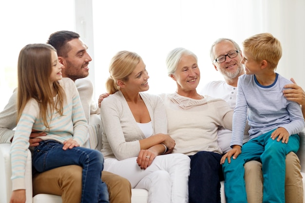 Concept de famille, de bonheur, de génération et de personnes - famille heureuse, assis sur un canapé à la maison