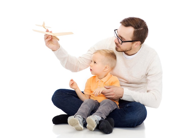 concept de famille, d'enfance, de paternité, de loisirs et de personnes - père heureux et petit fils jouant avec un avion jouet