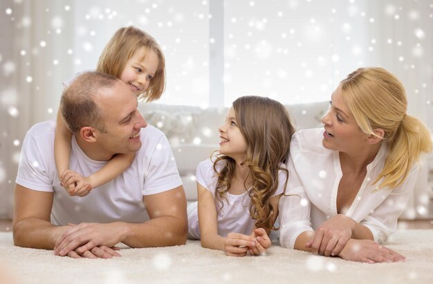 concept de famille, d'enfance, de personnes et de maison - parents souriants avec deux petites filles s'amusant à la maison