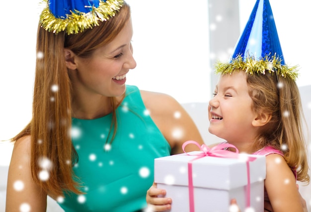 concept de famille, d'enfance, de vacances et de personnes - heureuse mère et fille en chapeaux de fête bleus avec boîte-cadeau