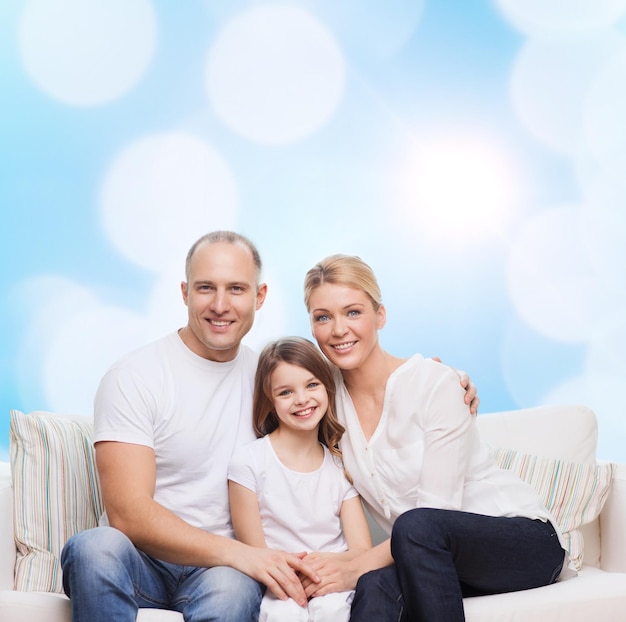 concept de famille, d'enfance, de vacances et de personnes - mère souriante, père et petite fille sur fond de lumières bleues