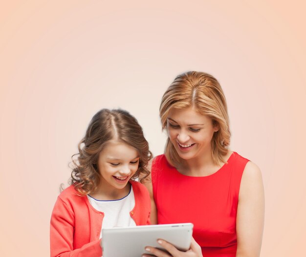 concept de famille, d'enfant et de technologie - mère et fille souriantes avec ordinateur tablette pc